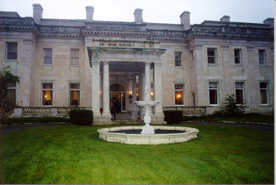 Fountain in front of two story mansion