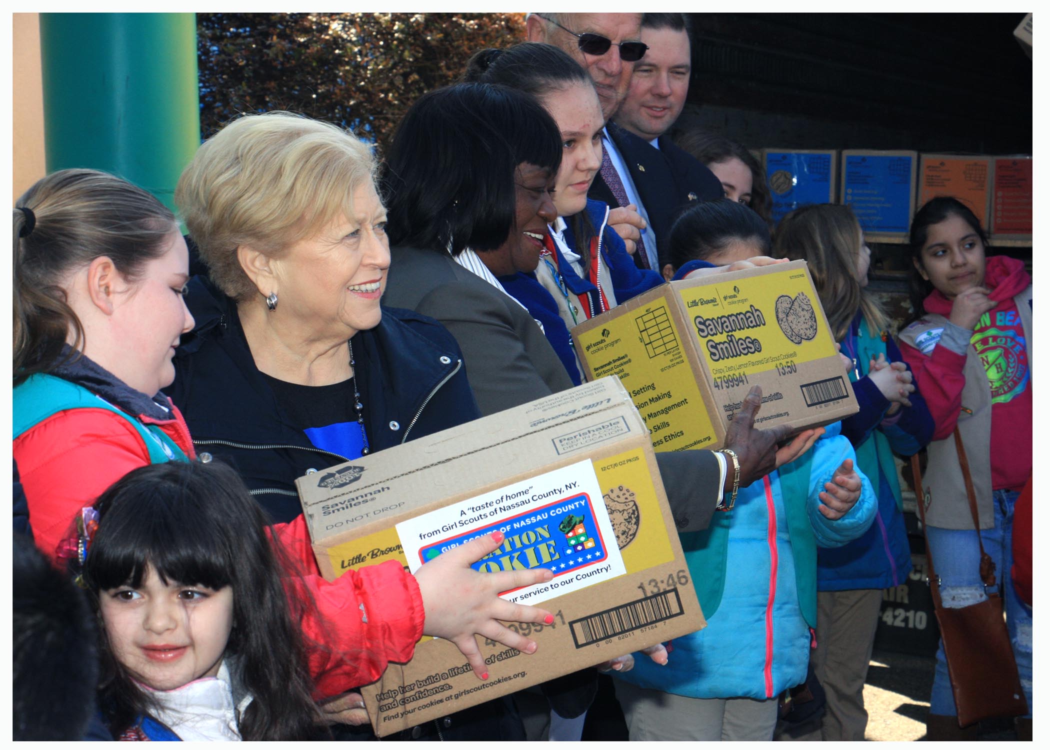 Legislator Judy Jacobs and local Girl Scouts are seen here loading Girl Scout Cookies onto DHL trucks before they are sent overseas to our soldiers abroad. 